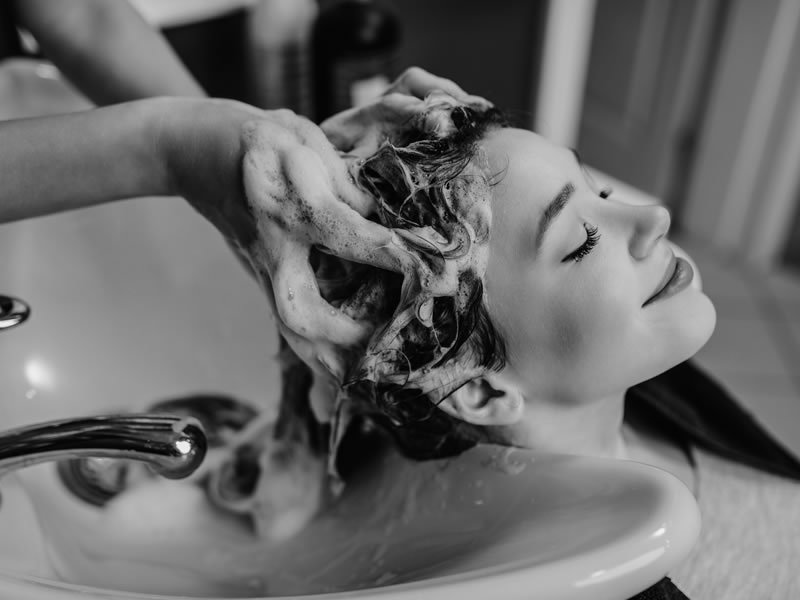 dott solari professoinal 25 Woman receiving a professional hair wash with Dott. Solari Professional products, showcasing product lines for salon use.
