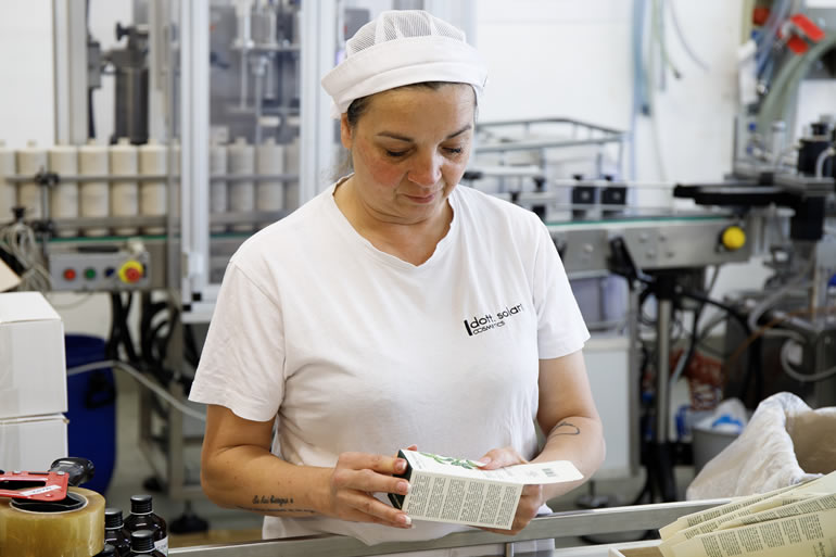 Dott. Solari Staff Barbara: Employee inspecting cosmetic product packaging on production line in factory. Quality control process.