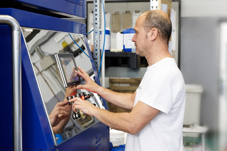 Dott. Solari Staff: Man operating industrial equipment with touch screen interface. Automated machinery control.